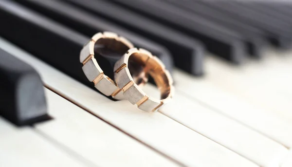 Two golden rings on the keys of the piano, close up — Stock Photo, Image