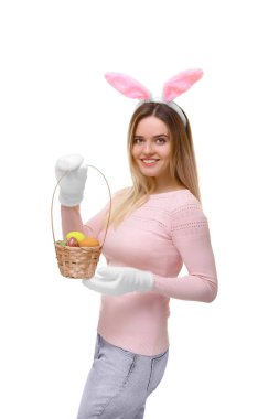 Kız tavşan kulaklı bir hasır sepet yumurta ile tutuyor. Beyaz arka plan üzerinde izole