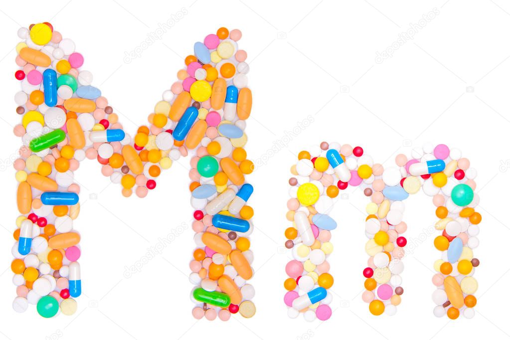Letter M, English alphabet, made, collected from medical tablets, pills, capsules, vitamin. Isolated on white background. Concept: ABC, design, logo, title, text, word