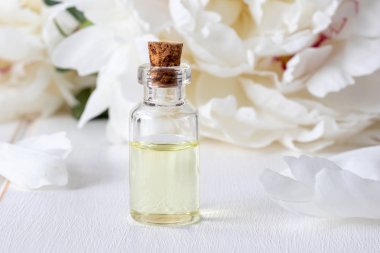 Esans taze beyaz şakayık çiçekleri arka plan ile bir şişe