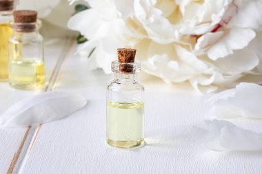 Esans taze beyaz şakayık çiçekleri ile şeffaf şişe