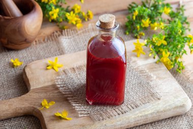 Bir şişe kırmızı yağı St John's wort çiçeklerden yapılmış