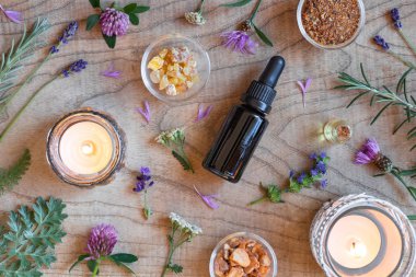 Esans buhur, çördük, pelin ve ahşap arka plan üzerinde diğer otlar ile şişe