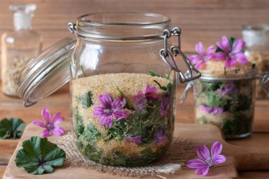 Vahşi ortak ebegümeci çiçek ve yaprakları ve şeker kamışı, öksürük karşı bitkisel şurup hazırlamak için dolu bir kavanoz