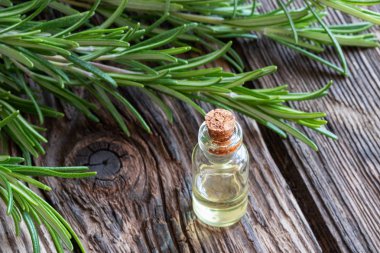 Esans rustik bir arka plan üzerinde dal taze biberiye ile bir şişe