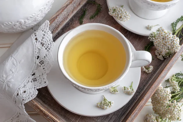 Yarrow tea in a white vintage cup with fresh twigs