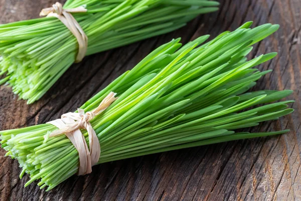 Fresh barley grass blades on a wooden background