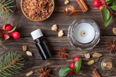 Esans buhur, mür, wintergreen ve kış baharat bir Noel zemin üzerine şişe