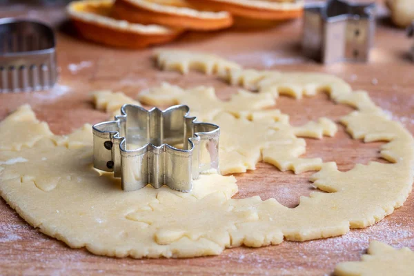 Cutting out star shapes from rolled out dough to prepare traditional Linzer Christmas cookies