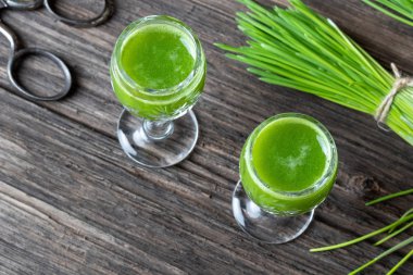 Arka planda taze bitki ve iki bardak arpa suyu.