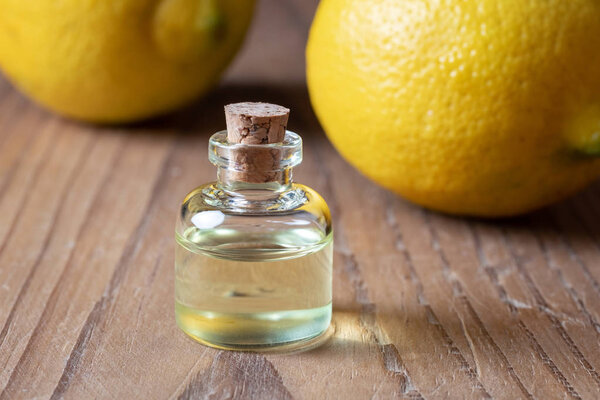 A bottle of essential oil with fresh lemons