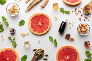 Taze greyfurt, nane şekeri, mür, beyaz sandal ağacı ve diğer malzemelerle birlikte gerekli yağ şişeleri.