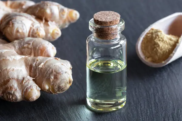 Eine Flasche Ätherisches Mit Ingwerwurzel Und Pulver — Stockfoto