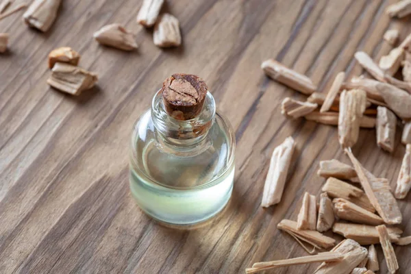 Een fles ceder etherische olie met stukken van cederhout — Stockfoto