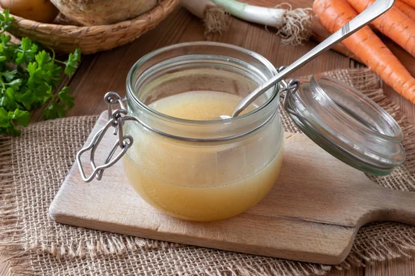 Chicken bone broth in a glass jar with fresh vegetables — Stock Photo, Image