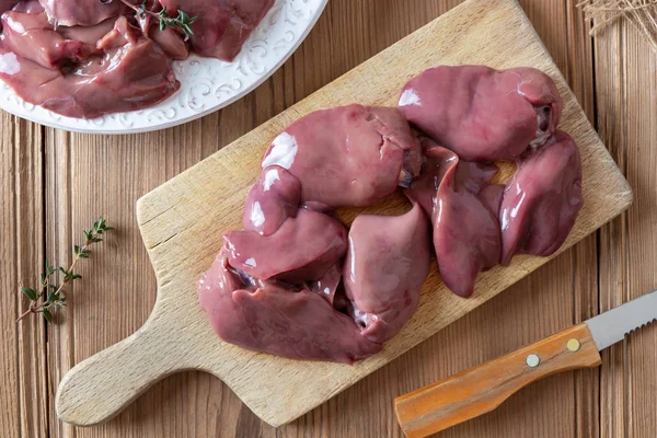 Levers van verse rauwe kip op een snijplank — Stockfoto