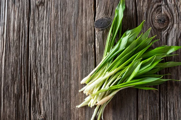 Fresh wild garlic leaves on a wooden background — Stock Photo, Image