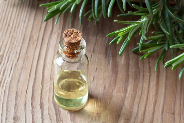 Een fles van rozemarijn etherische olie met verse rozemarijn — Stockfoto