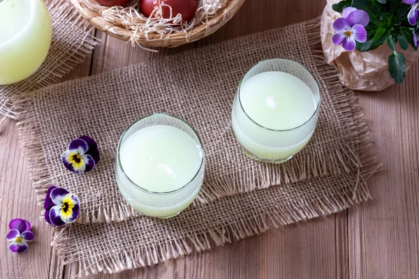 Two glasses of fresh whey and pansy flowers — Stock Photo, Image