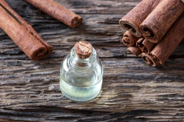 Een fles van kaneel etherische olie met kaneel stokjes — Stockfoto