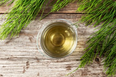 Taze at kuyruğu dallı bir fincan bitki çayı.