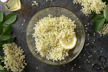 Şurubu hazırlamak için suda yaşlı çiçekler macerating