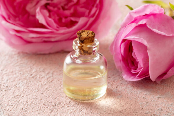 Бутылка розового эфирного масла с цветами роз
