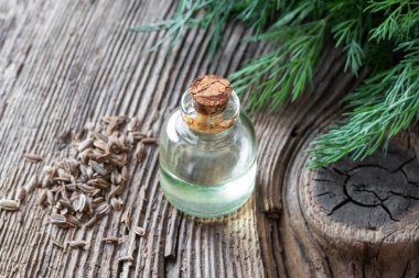 Dereotlu ve yapraklı bir şişe dereotu tohumu yağı.