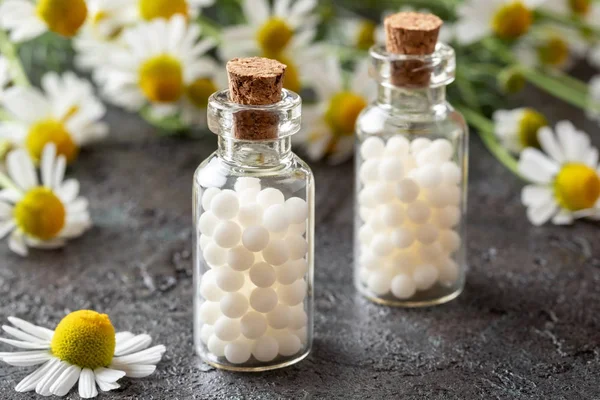 Bottles of homeopathic pills with chamomile flowers — Stock Photo, Image