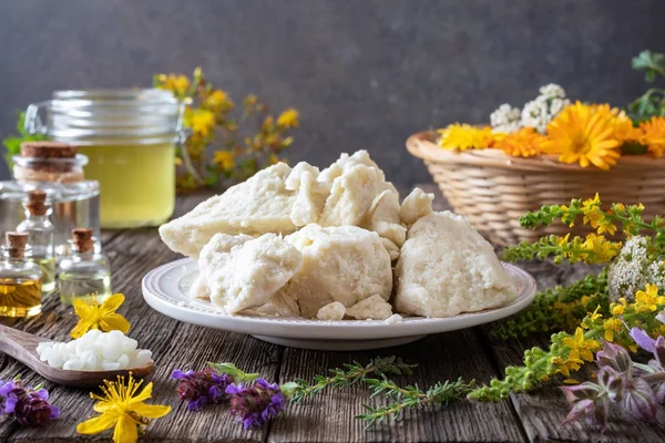 Shea butter on a plate, essential oils and herbs