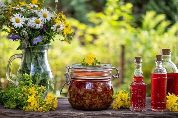 Flasker af rød olie fremstillet af St. John 's wort blomster - Stock-foto