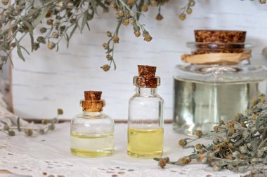 Bottles of essential oil with fresh wormwood