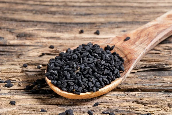 Семена черного тмина на деревянной ложке — стоковое фото