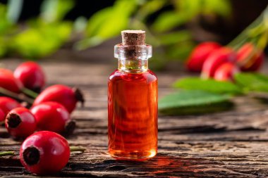 Bir şişe gül tohumu yağı ve taze böğürtlen.