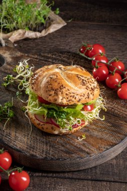 Tahta bir masada taze lahanalı ve mikro yeşillikli hamburger.