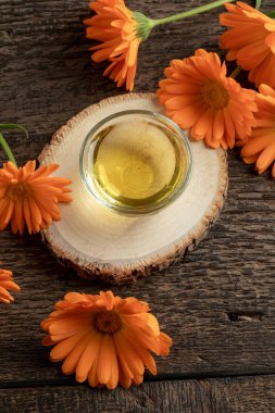 Taze turuncu takvim çiçekli bir kase gerekli yağ.