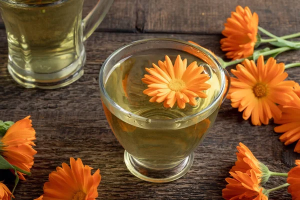 Egy Csésze Napendula Tea Friss Virágokkal Egy Asztalon — Stock Fotó