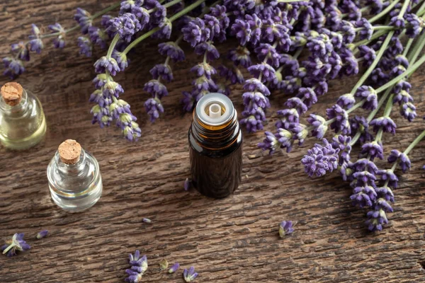 Een Donkere Fles Etherische Olie Met Verse Bloeiende Lavendel Een — Stockfoto