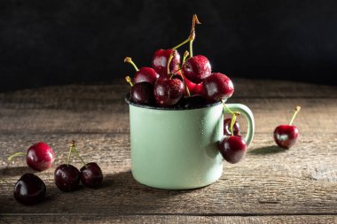 Masadaki tencerede taze kirazlar