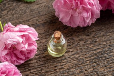 Taze güllerle birlikte bir şişe gerekli yağ.