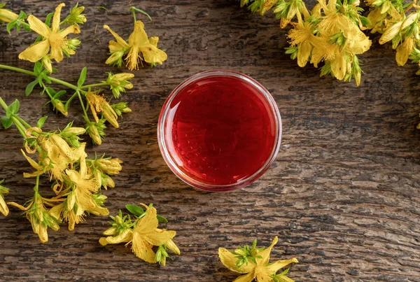セントジョンズの麦汁の花から作られた赤い油をボウルに入れ 上からの眺め — ストック写真