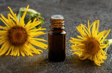 Masanın üzerinde siyah bir şişe elektroampan yağı var.