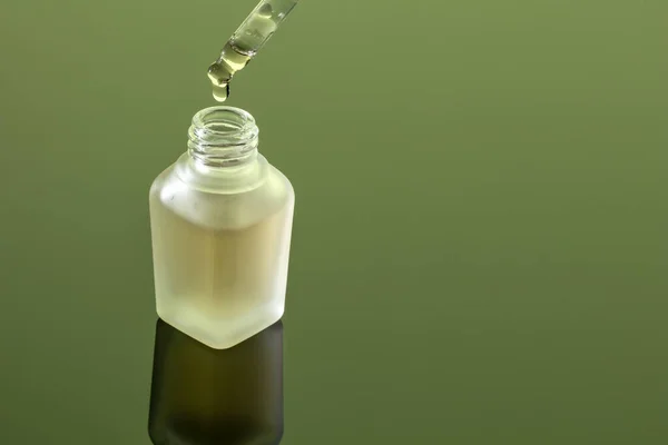Una Gota Aceite Esencial Cayendo Una Botella Sobre Fondo Verde —  Fotos de Stock