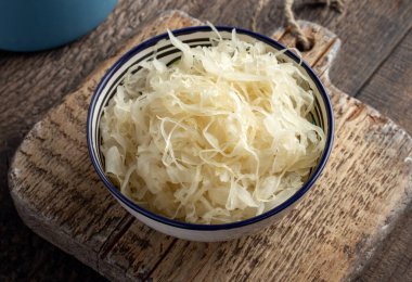 A bowl of fermented cabbage on a table clipart