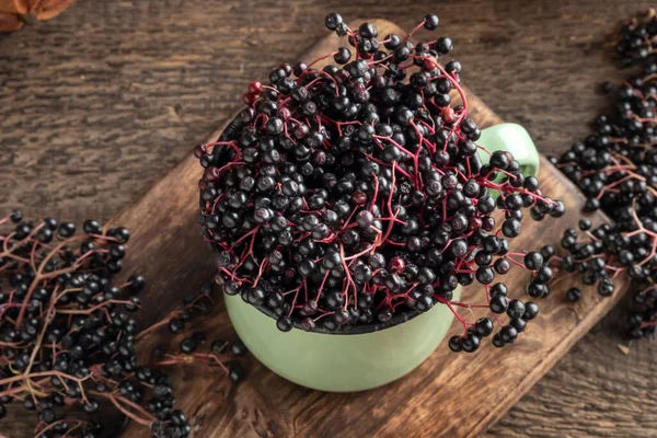 Black elder berries in a green pot on a table