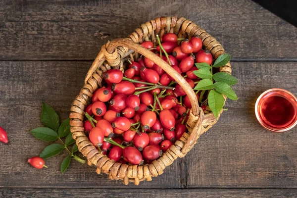 Rose hips in a basket on a table, top view