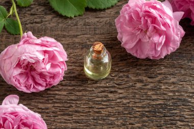 Taze Rose de Mai çiçekleriyle dolu bir şişe yağ. Kopya alanı da var.