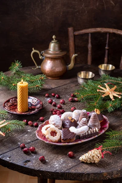 传统的圣诞饼干放在桌上 有干枯的玫瑰臀 云杉枝条和稻草装饰 — 图库照片