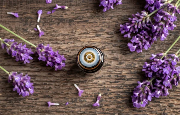 Een Donkere Fles Etherische Olie Met Verse Bloeiende Lavendel Een — Stockfoto