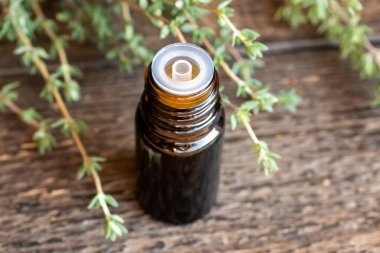 Taze kekik dallarıyla birlikte bir şişe gerekli yağ.